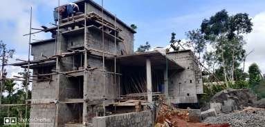 Valley Twin House under construction with scaffolding on the stone tower